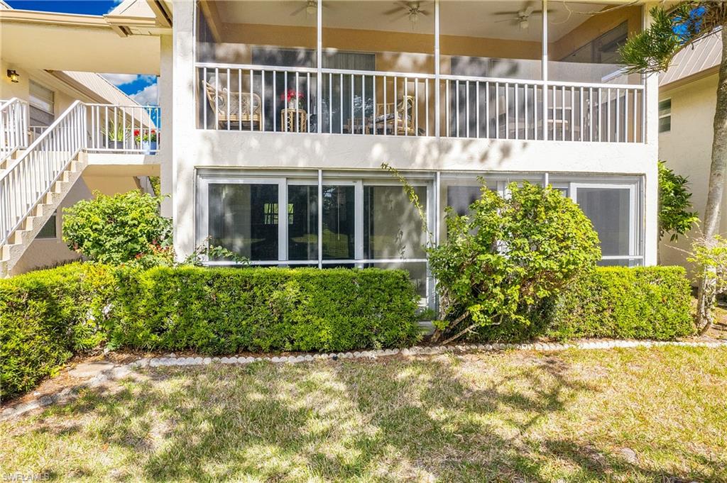 1549 Sandpiper Street, Unit 89 Naples, FL 34102 - Photo 1 of 11 a view of a house with a small yard and plants