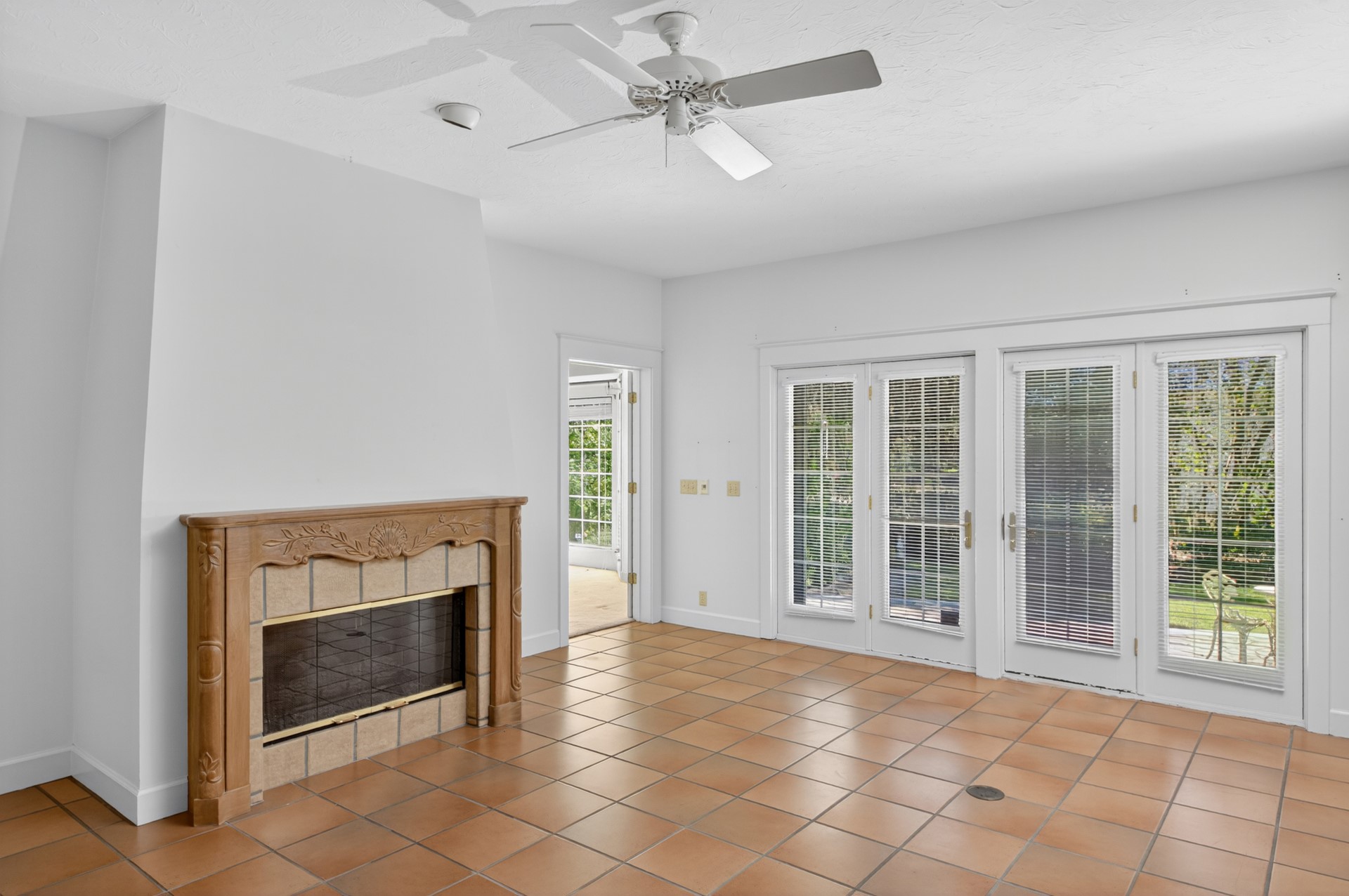 7 Hickory Lane Fernandina Beach, FL 32034 - Photo 17 of 42 an empty room with windows a fireplace and a chandelier fan