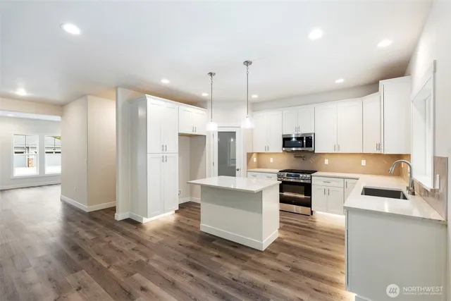a kitchen with a refrigerator and a stove top oven
