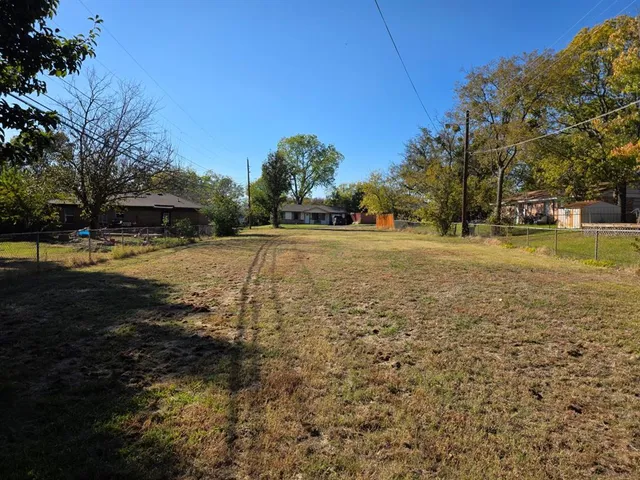 a view of a yard with plants and trees
