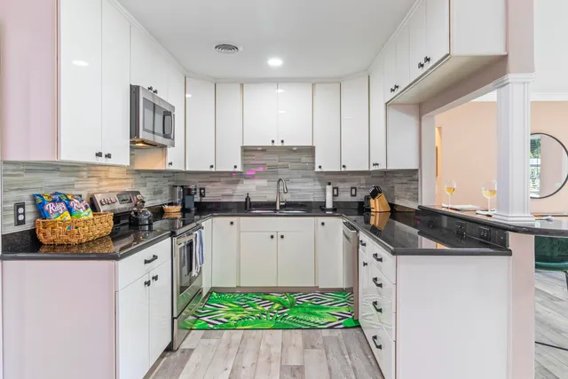 a kitchen with stainless steel appliances granite countertop a sink stove and cabinets