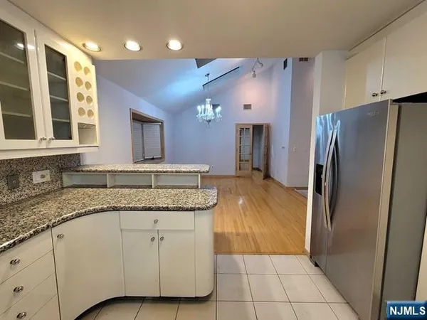 a kitchen with granite countertop a refrigerator and a sink