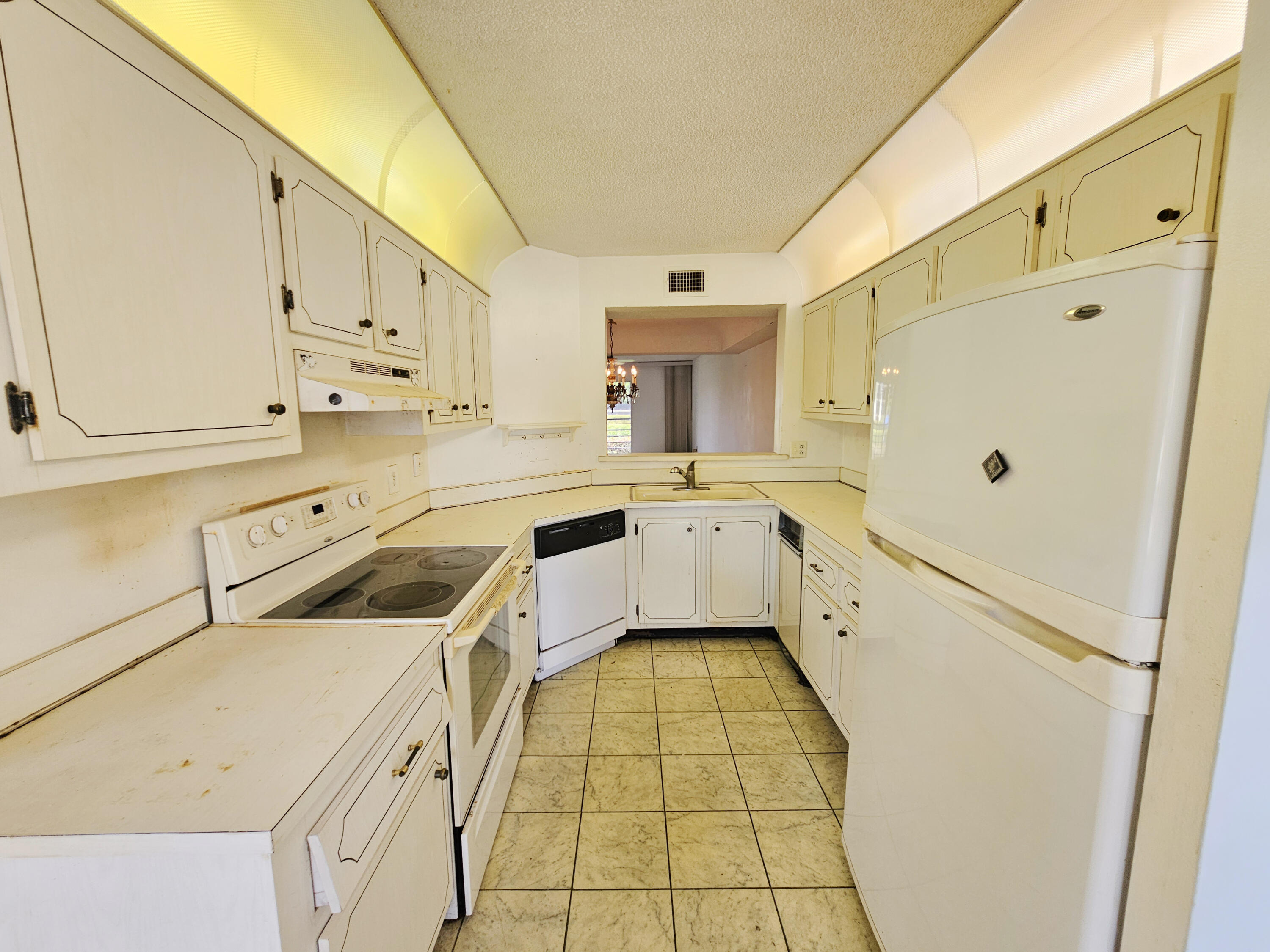 23385 South Barwood Lane, Unit 1203 Boca Raton, FL 33428 - Photo 7 of 22 a kitchen with white cabinets and white appliances