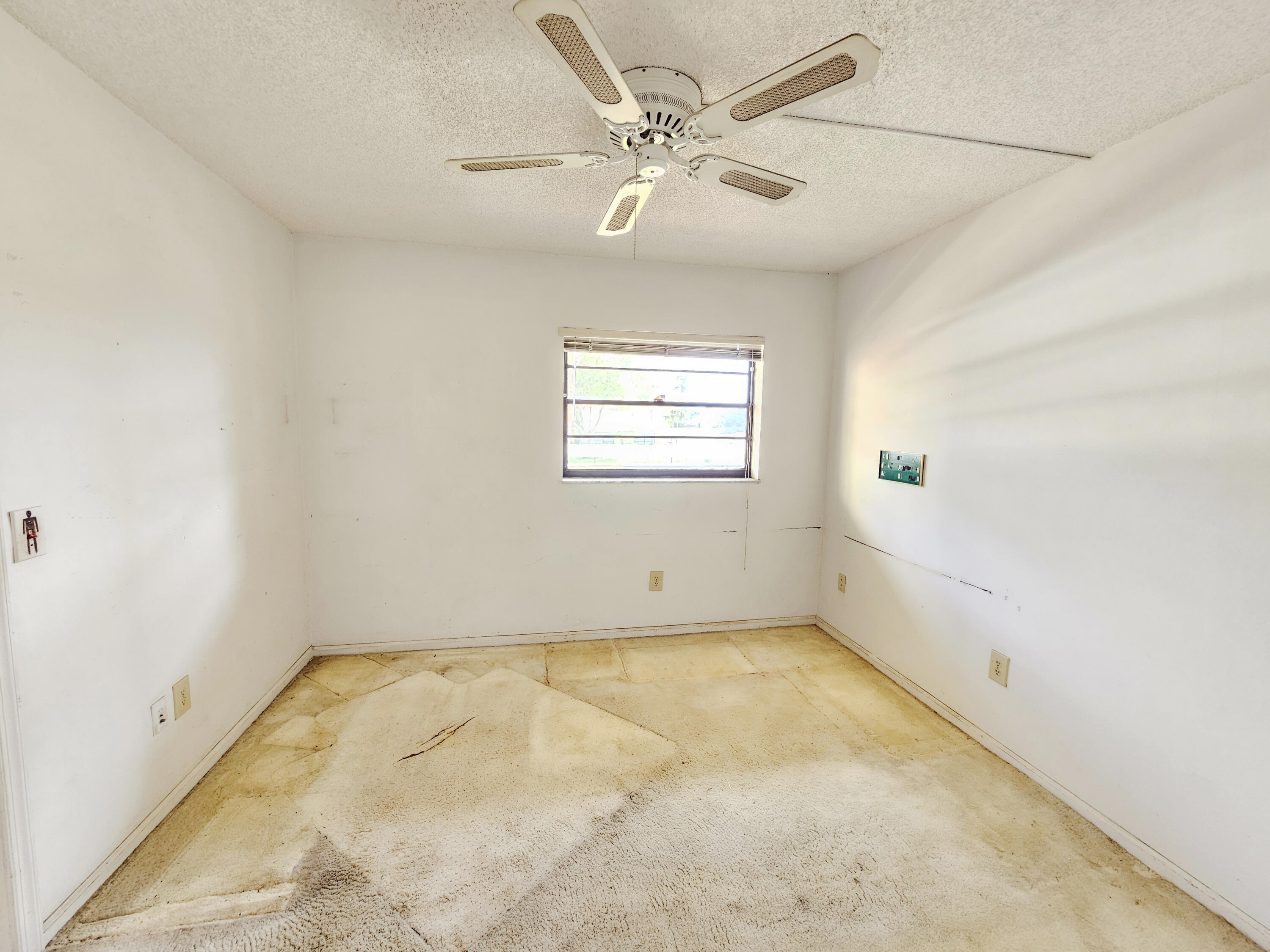 23385 South Barwood Lane, Unit 1203 Boca Raton, FL 33428 - Photo 10 of 22 an empty room with a window and a ceiling fan