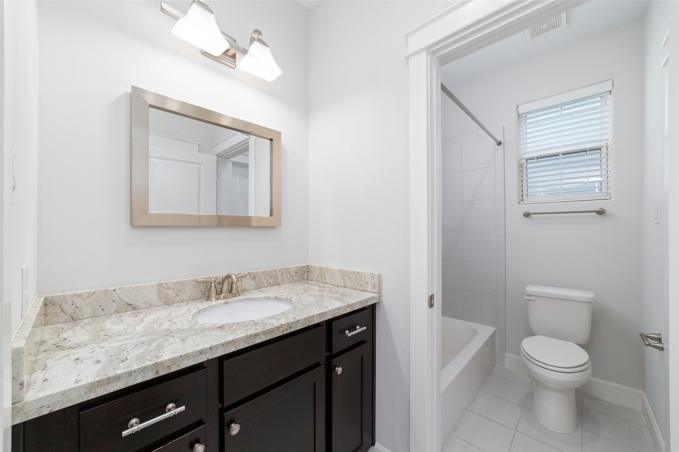902 West 20th Street, Unit A Houston, TX 77008 - Photo 12 of 23 a bathroom with a granite countertop sink toilet and mirror