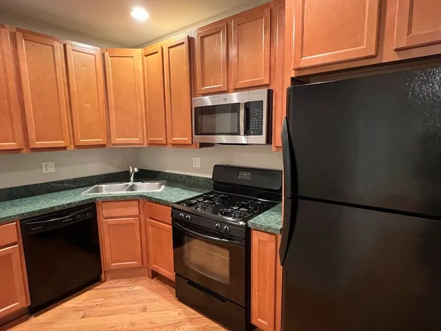 a kitchen with granite countertop wooden cabinets and a stove top oven