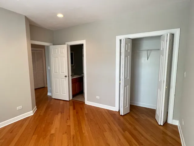 an empty room with wooden floor and closet