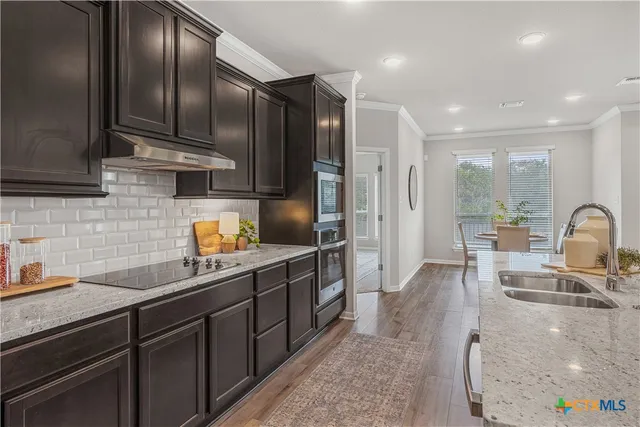a kitchen with stainless steel appliances a sink a stove and a refrigerator