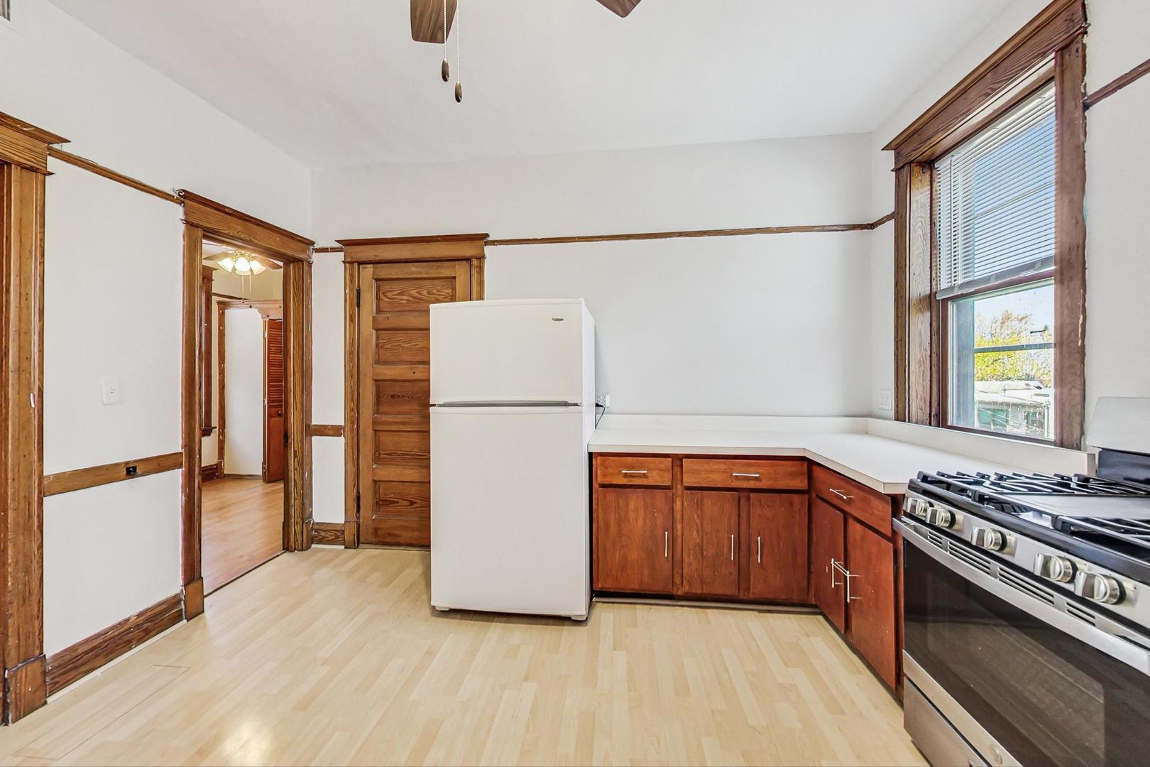 1646 West Byron Street, Unit 3F Chicago, IL 60613 - Photo 14 of 30 a kitchen with wooden cabinets and white appliances