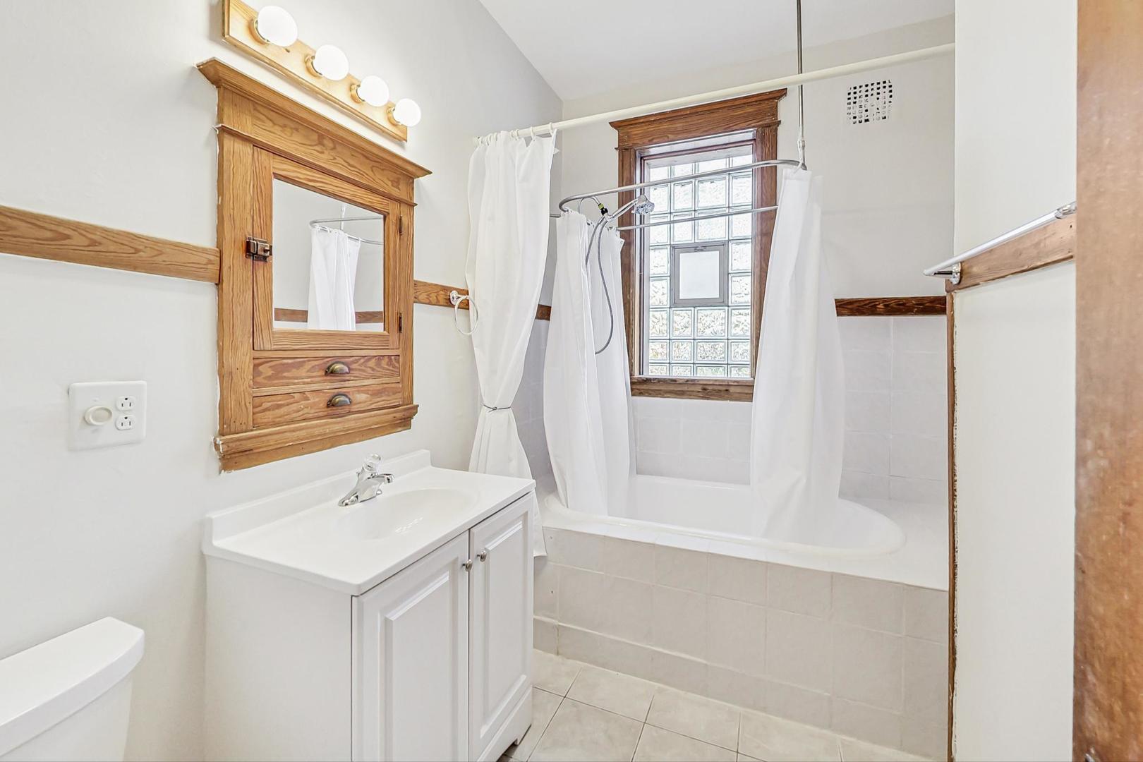 1646 West Byron Street, Unit 3F Chicago, IL 60613 - Photo 25 of 30 a bathroom with a sink a toilet and shower
