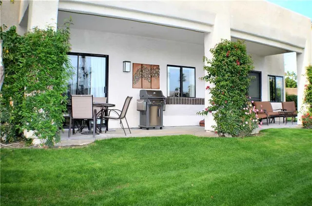a view of a chair and table in backyard of the house