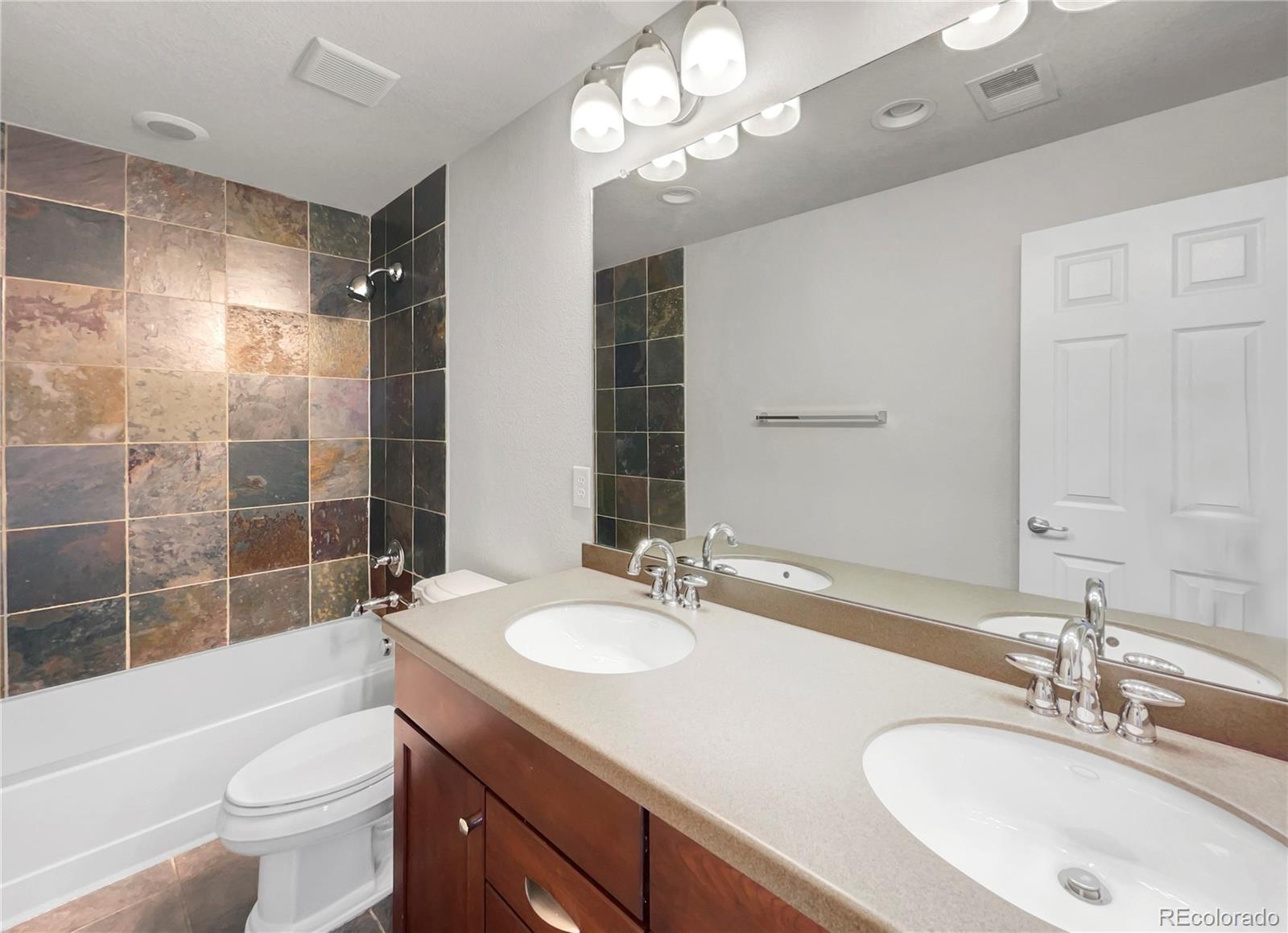 2380 Xanthia Way Denver, CO 80238 - Photo 14 of 19 a bathroom with a sink a toilet a large mirror and shower