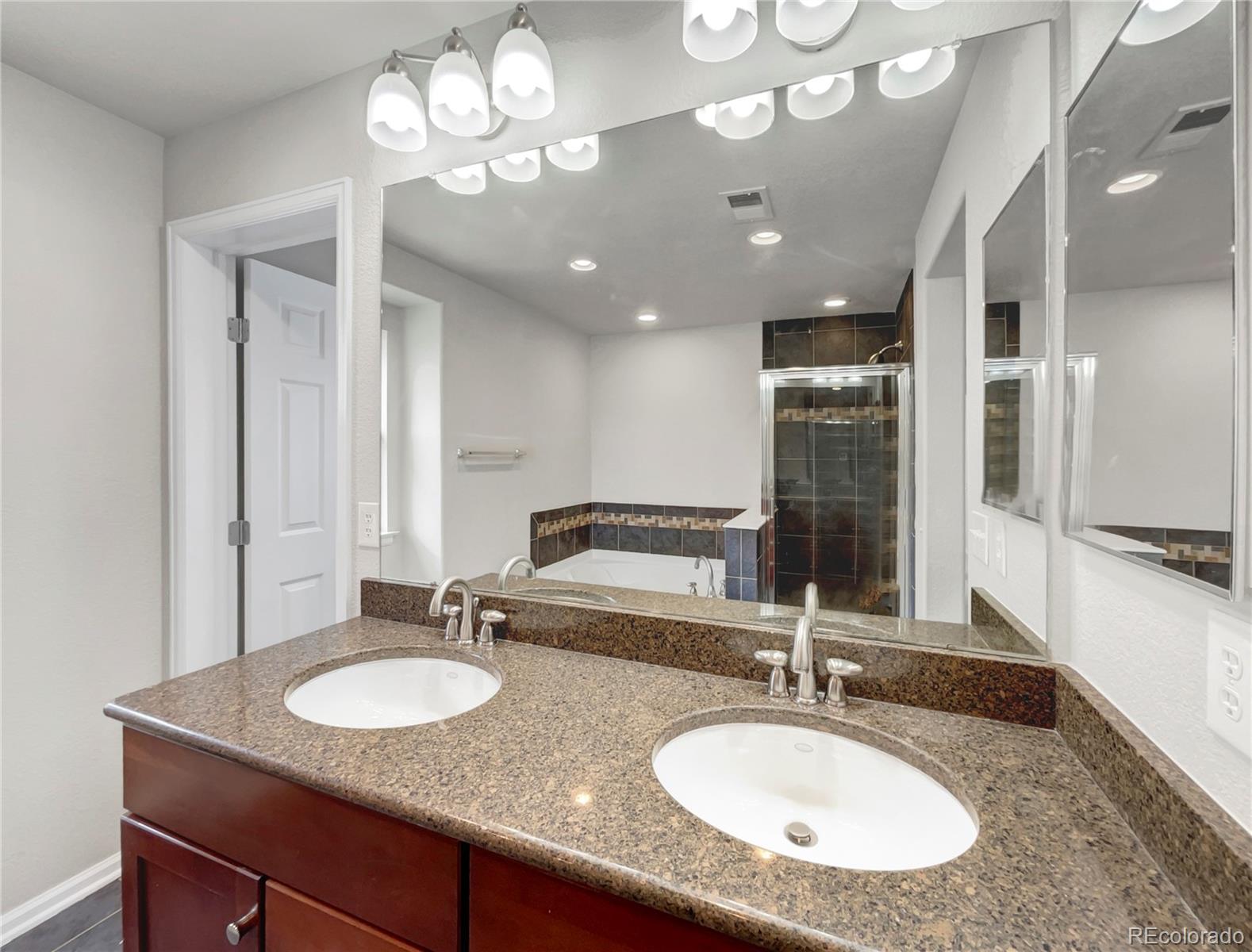 2380 Xanthia Way Denver, CO 80238 - Photo 15 of 19 a bathroom with a granite countertop double vanity and a mirror