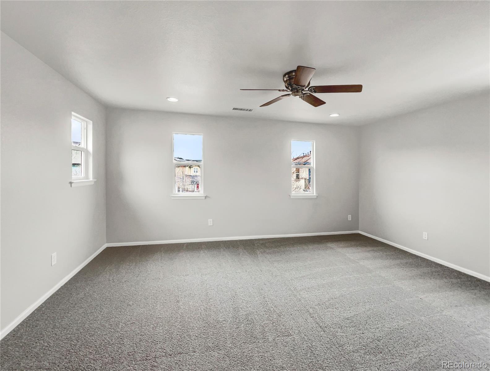 2380 Xanthia Way Denver, CO 80238 - Photo 17 of 19 an empty room with windows and ceiling fan