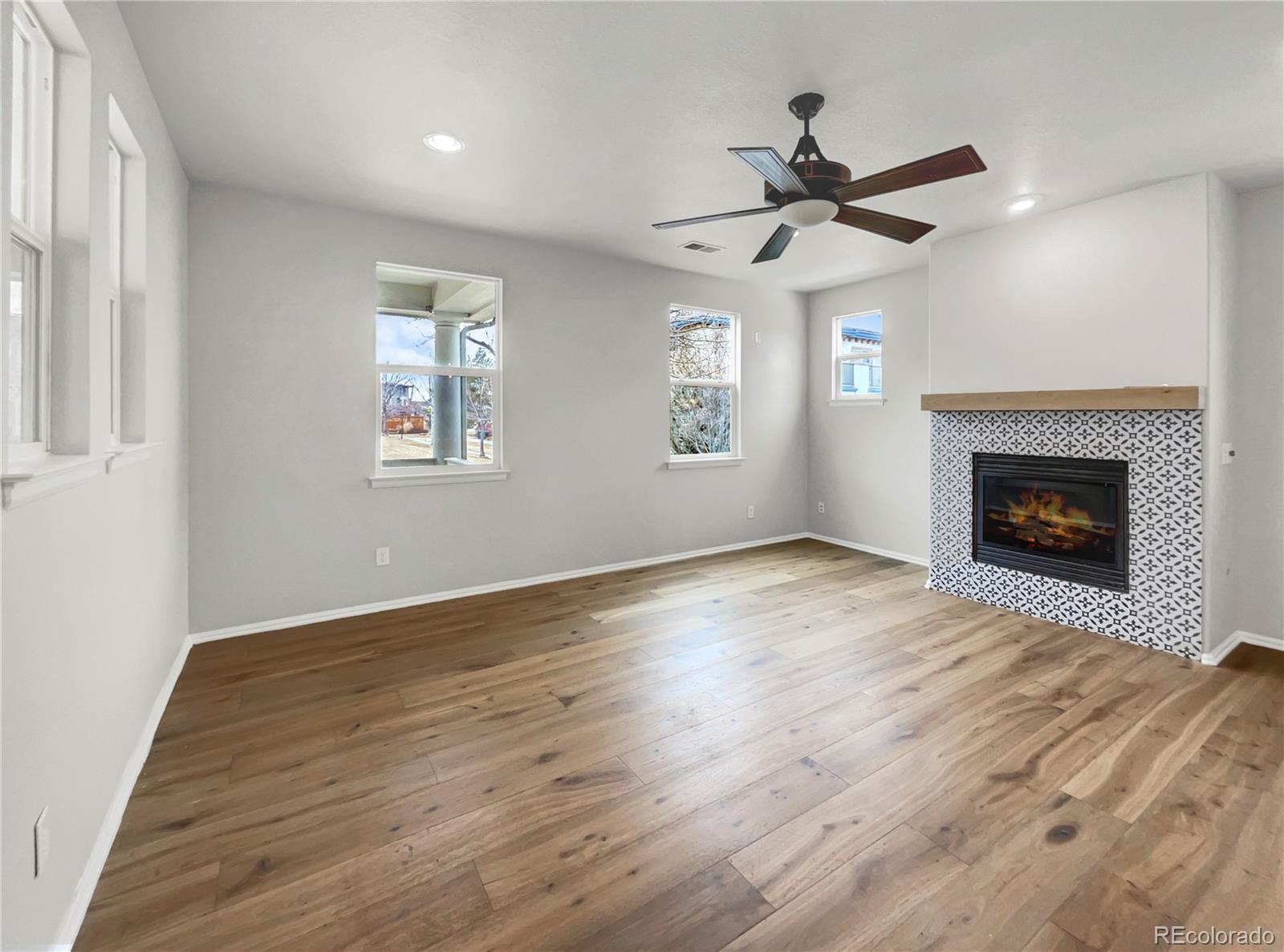 2380 Xanthia Way Denver, CO 80238 - Photo 3 of 19 wooden floor fireplace and windows in an empty room