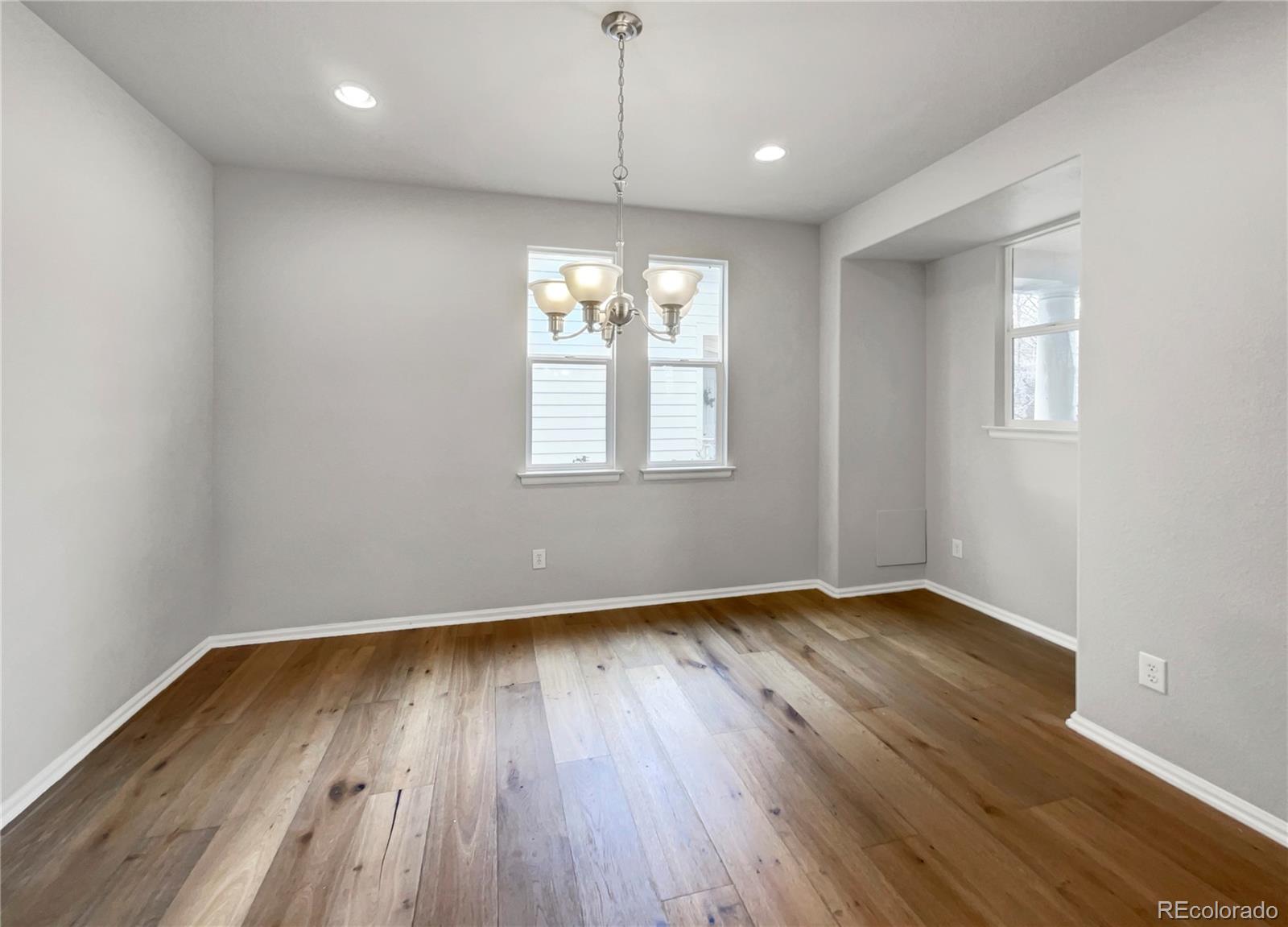 2380 Xanthia Way Denver, CO 80238 - Photo 8 of 19 an empty room with wooden floor and windows