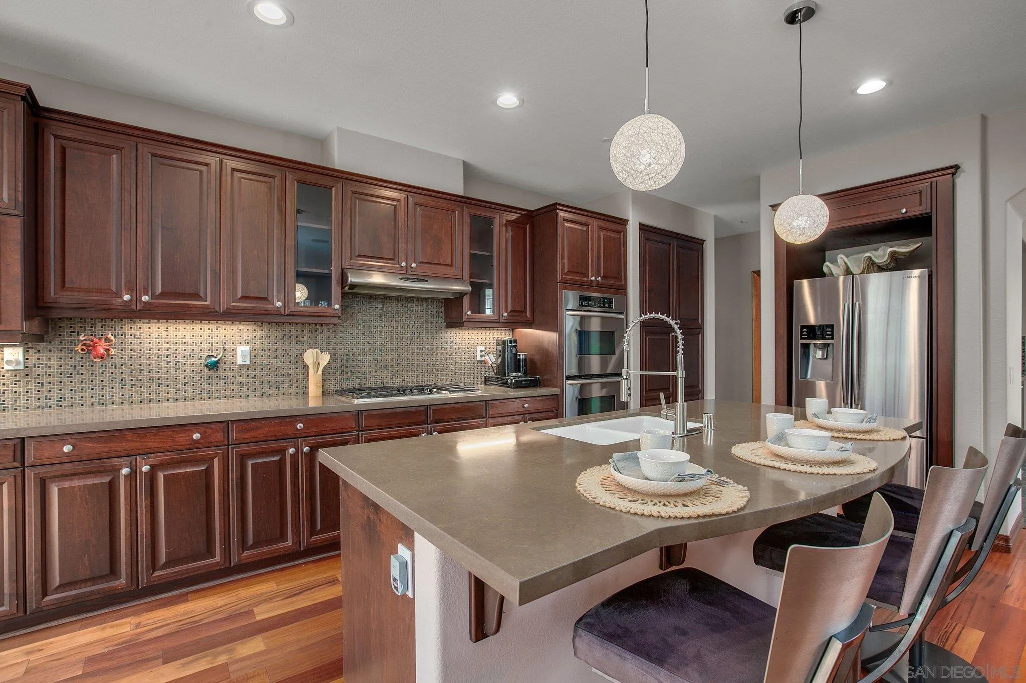 1104 Sagewood Drive Oceanside, CA 92056 - Photo 6 of 46 a kitchen with a table chairs stove and microwave