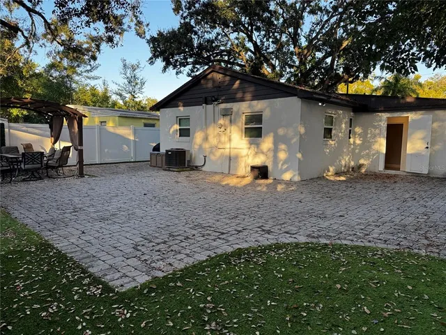 a view of a house with backyard and sitting area
