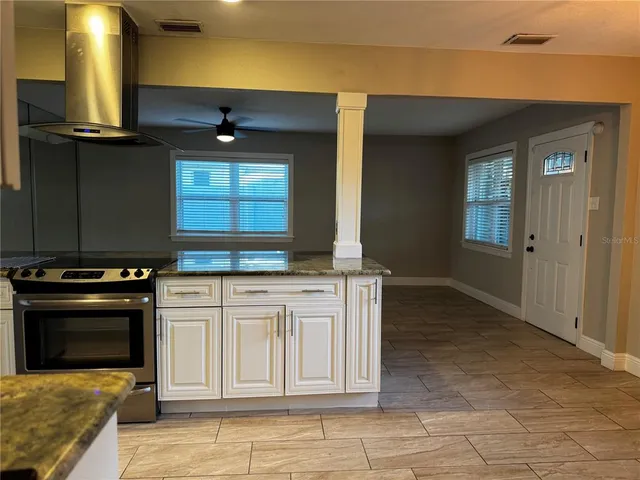a kitchen with stainless steel appliances granite countertop a stove a sink and a microwave