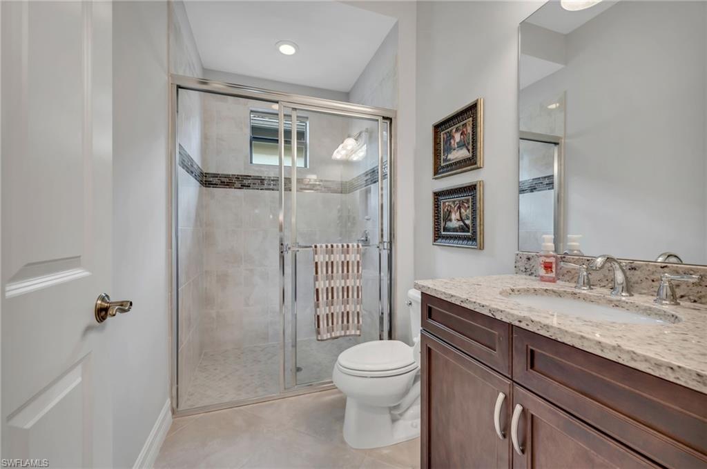 6714 Canwick Cove Circle Naples, FL 34113 - Photo 12 of 23 a bathroom with a granite countertop sink toilet and shower