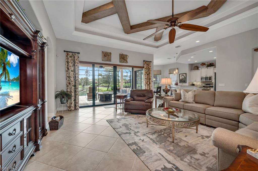 6714 Canwick Cove Circle Naples, FL 34113 - Photo 3 of 23 a living room with furniture a ceiling fan and a flat screen tv