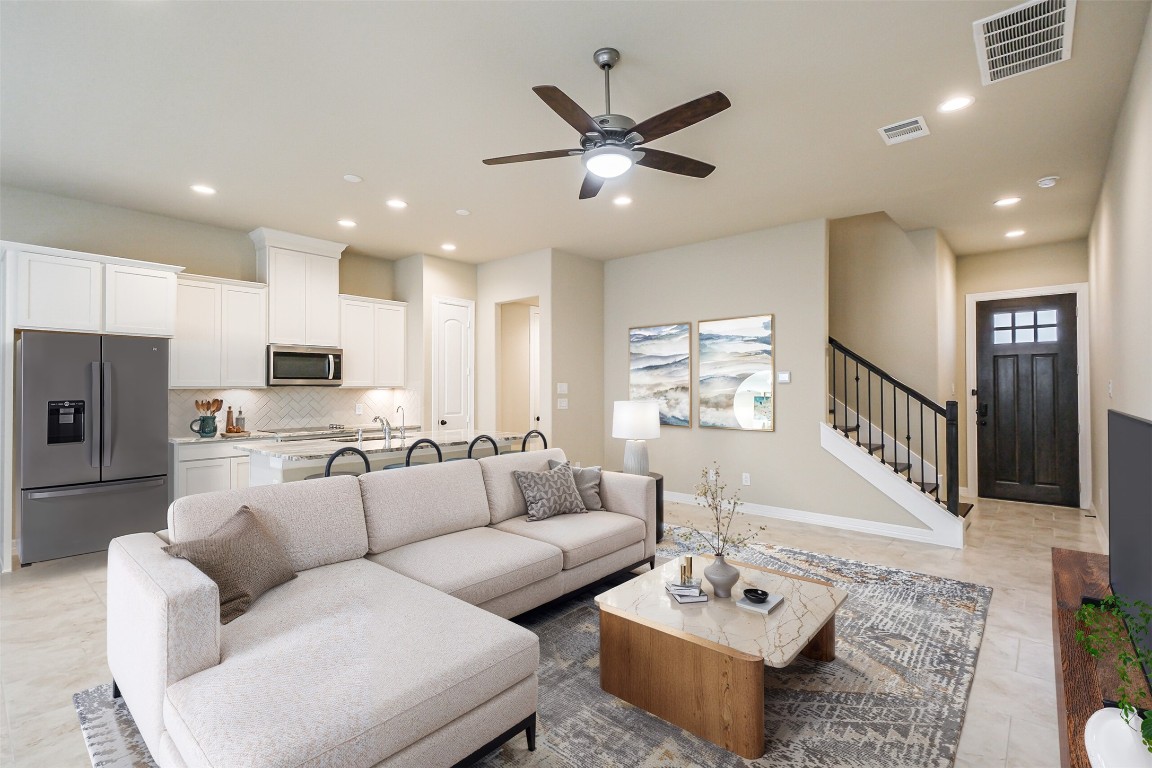 a living room with furniture and a view of kitchen