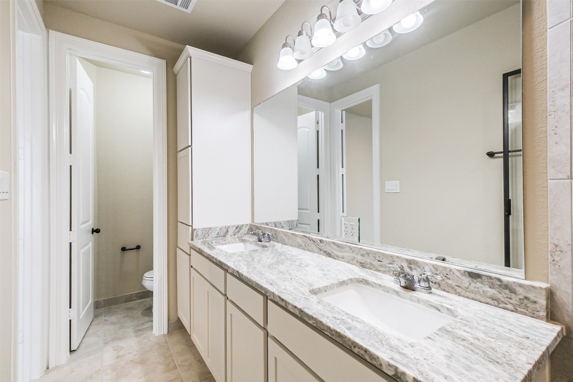 11005 Cres Light Way Houston, TX 77043 - Photo 11 of 22 a bathroom with a granite countertop double vanity sink mirror and shower