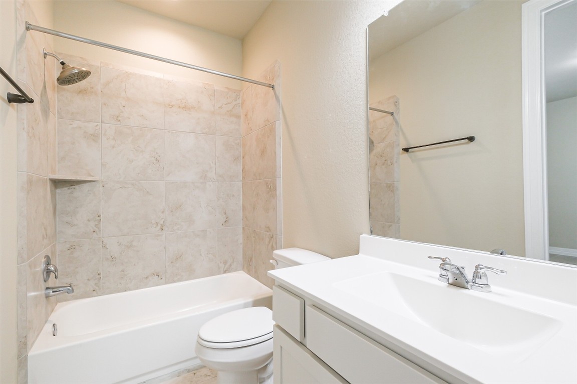 11005 Cres Light Way Houston, TX 77043 - Photo 17 of 22 a bathroom with a granite countertop sink a toilet and shower