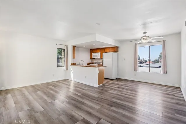 a view of a kitchen with wooden floor and a window