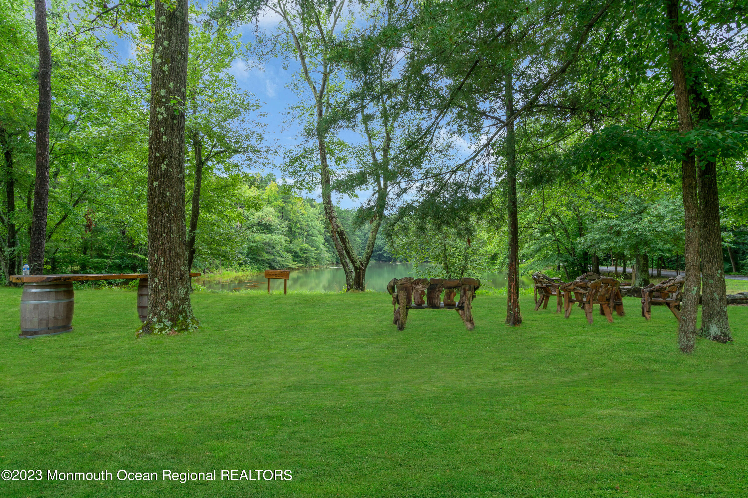 724 Monmouth Road, Unit 33 Cream Ridge, NJ 08514 - Photo 23 of 27 a view of a bench in the garden near a lake