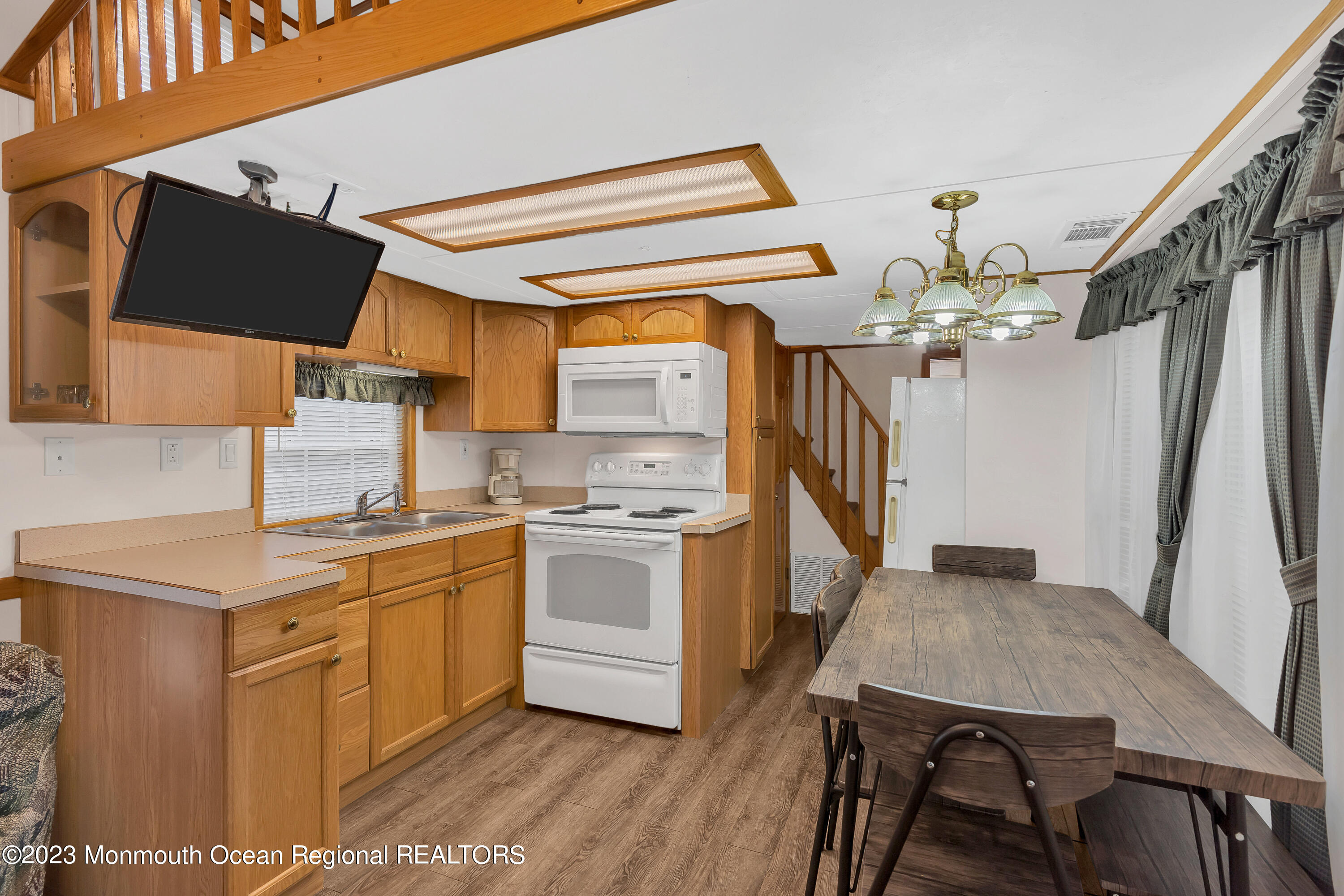 724 Monmouth Road, Unit 33 Cream Ridge, NJ 08514 - Photo 5 of 27 a kitchen that has a sink stainless steel appliances a counter space and wooden floor