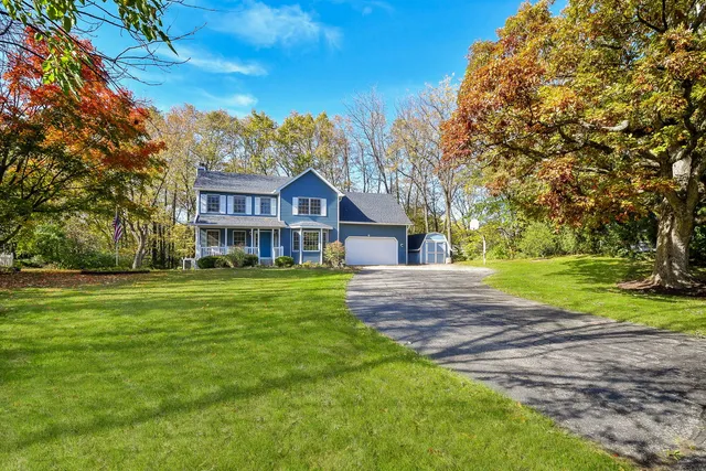 a view of a big house with a big yard and large trees