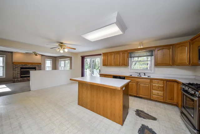 a kitchen with stainless steel appliances granite countertop a stove cabinets and wooden floor