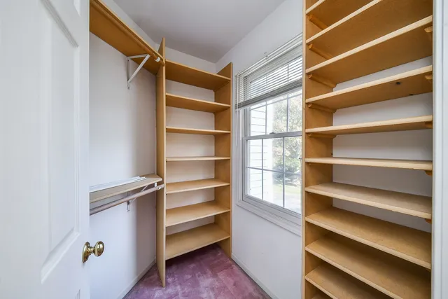 a view of walk in closet with empty racks