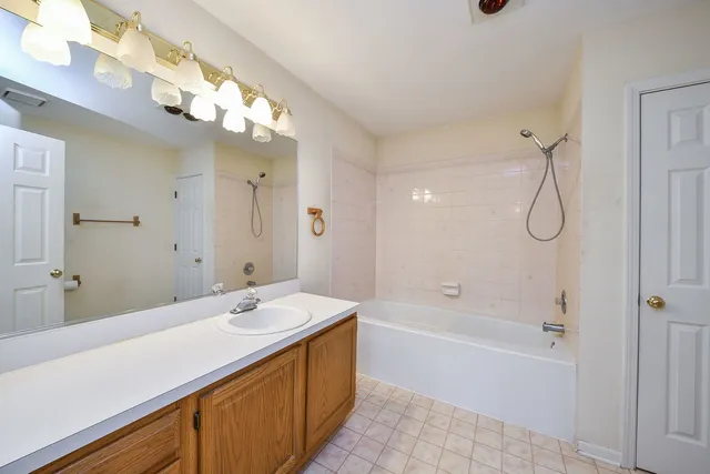 a bathroom with a tub a sink and mirror