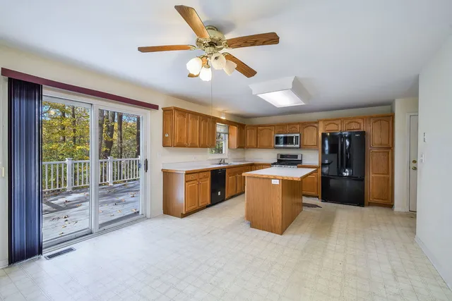 a kitchen with stainless steel appliances kitchen island granite countertop a refrigerator a stove top oven a sink and dishwasher