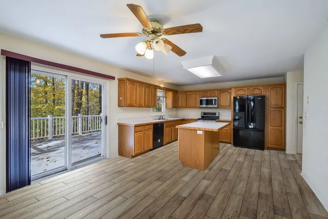a kitchen with kitchen island wooden floors and stainless steel appliances