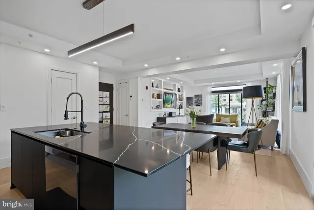 a kitchen with kitchen island stainless steel appliances sink dining table and chairs