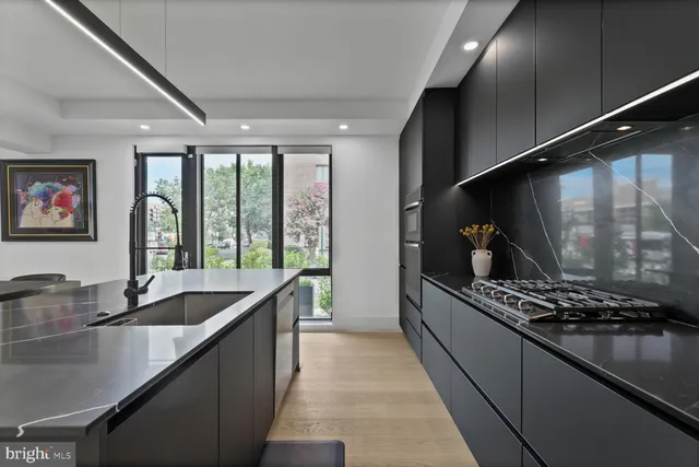 a kitchen with stainless steel appliances a sink stove and cabinets