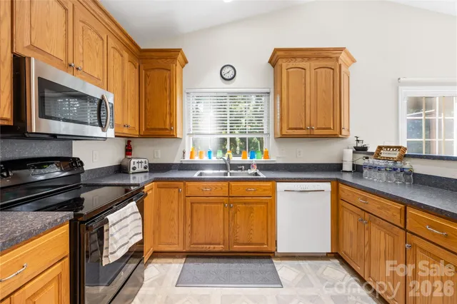 a kitchen with stainless steel appliances granite countertop a stove sink and cabinets