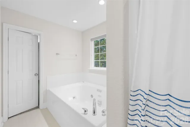 a spacious bedroom with a bed and a window