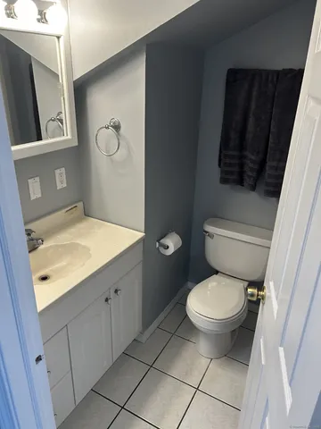a bathroom with a granite countertop toilet sink and mirror