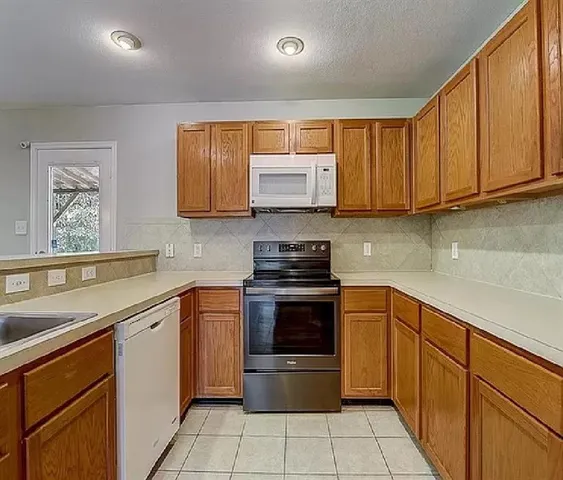 a kitchen with stainless steel appliances granite countertop wooden cabinets a stove top oven a sink and dishwasher