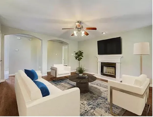 a living room with furniture a fireplace and a flat screen tv