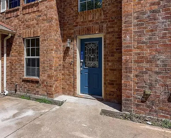 a brick building with a door and a yard