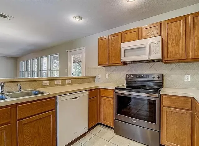 a kitchen with stainless steel appliances granite countertop a sink and stove top oven