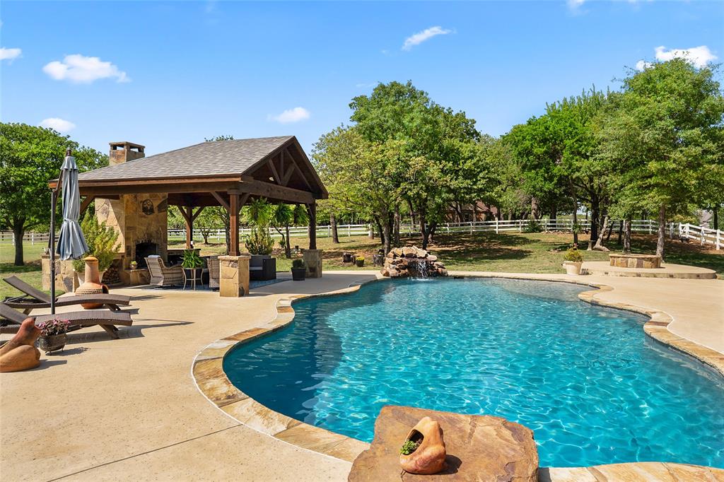 419 East Hickory Ridge Circle Argyle, TX 76226 - Photo 35 of 37 a view of a swimming pool with lawn chairs under an umbrella