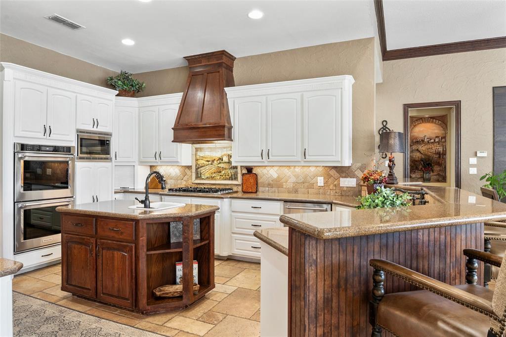 419 East Hickory Ridge Circle Argyle, TX 76226 - Photo 5 of 37 a kitchen with kitchen island granite countertop a sink counter top space appliances and cabinets