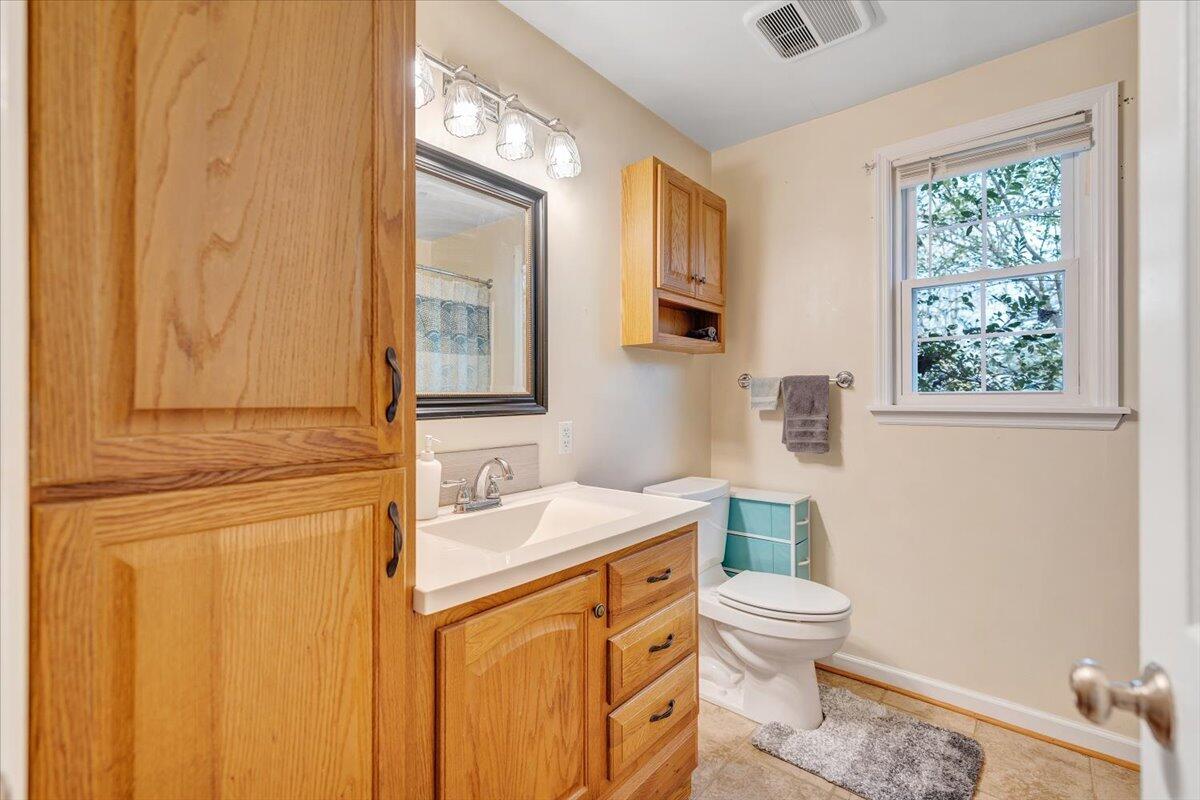 4915 Hildebrand Road Northwest Roanoke, VA 24012 - Photo 22 of 40 a bathroom with a toilet a sink and a mirror
