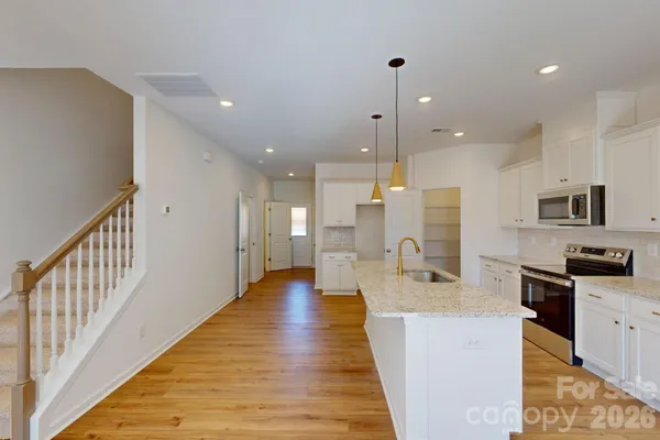 a large kitchen with stainless steel appliances kitchen island granite countertop a large island in the center